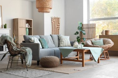 Oturma odasının içinde kanepe, koltuk ve nane minderleri var.