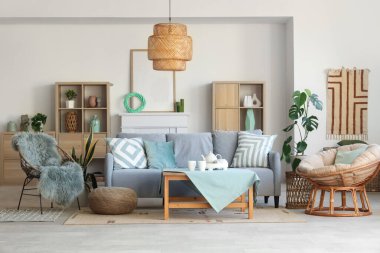 Oturma odasının içinde kanepe, koltuk ve nane minderleri var.