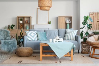 Oturma odasının içinde kanepe, koltuk ve nane minderleri var.