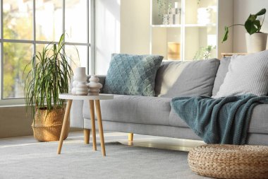 Masasında vazo ve kanepe olan oturma odasının içinde.