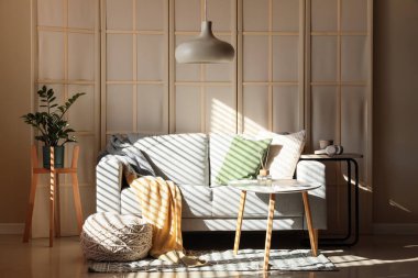 Katlanmış perdeli, kanepeli ve masalı bir oturma odası.