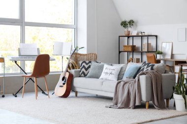 Kanepesi, sentezleyicisi ve gitarı olan bir oturma odası.