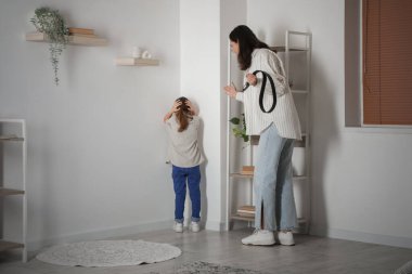 Kemerli bir anne, kızını tehdit ediyor. Aile içi şiddet kavramı