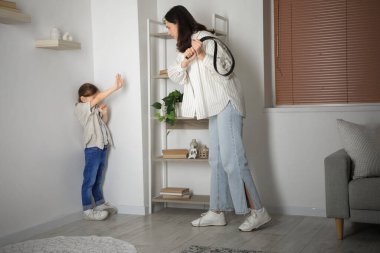 Kemerli bir anne evde kızını tehdit ediyor. Aile içi şiddet kavramı