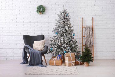Oturma odasının içinde koltuk, Noel ağacı ve merdiven var.