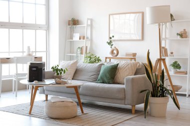 Masasında kanepe, bitki ve taşınabilir elektrik santrali olan bir oturma odası.