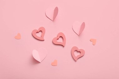 Ahşap ve pembe zemin üzerinde kağıt kalpler olan kompozisyon. Sevgililer Günü kutlaması