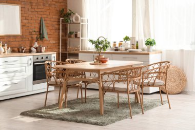 Mutfağın içinde yemek masası, raf ünitesi ve bitkiler var.