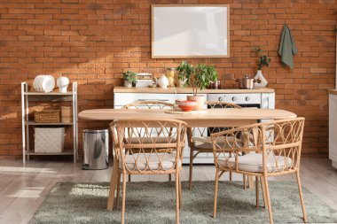 Mutfağın içinde yemek masası, raf ünitesi ve boş çerçeve.