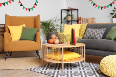 Kwanzaa için dekore edilmiş oturma odasının içinde kanepe, koltuk ve masa var.