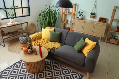 Masada Kwanza kutlaması için kanepe, mum ve meyveli şık bir oturma odası.