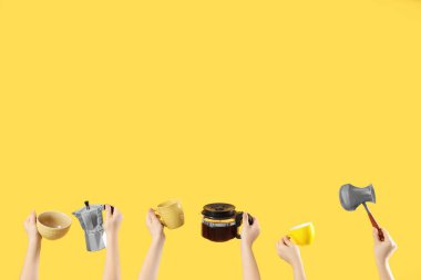 Fincanlı kadın eller, kahve makinası ve sarı arka planda çakmak. Günaydın konsept.