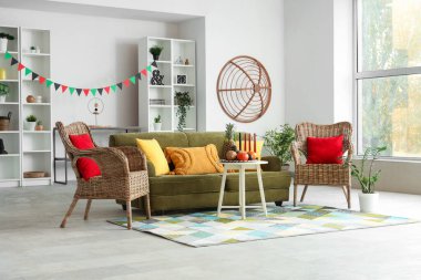 Oturma odasının içinde yeşil kanepe, mum ve Kwanzaa kutlaması için yemek.