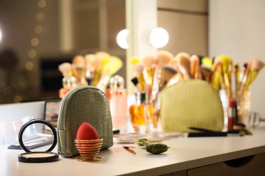 Kozmetik çanta ve odadaki farklı makyaj fırçaları.