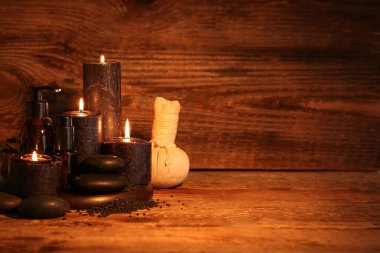 Koyu ahşap arka planda kaplıca aksesuarları ve kozmetik ürünleri olan güzel bir spa kompozisyonu.