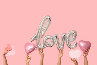 Hediye kutusu, zarf, aşk ve pembe arka planda kalp şeklinde hava balonları olan kadın elleri. Sevgililer Günü kutlaması