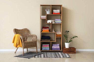 Koltuğu, raf ünitesi ve katlanmış kışlık giysileri olan soyunma odasının içinde.