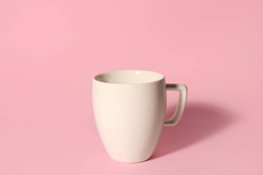 Pembe arka planda beyaz seramik bardak