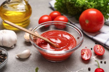 Bir kase taze domates ezmesi, sebze, baharat ve yağ.