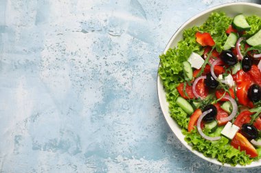Renkli arkaplanda bir kase lezzetli Yunan salatası