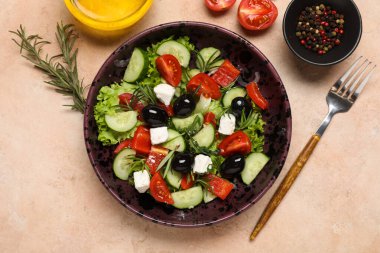 Bir kase lezzetli Yunan salatası, çatal, yağ ve baharat.