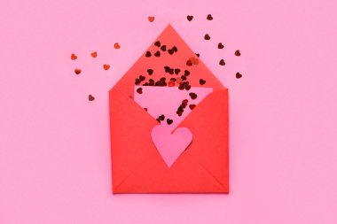 Zarfta pembe arka planda kalp şeklinde pullar var. Sevgililer Günü kutlaması