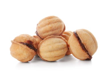 Beyaz arka planda kaynamış konsantre sütle pekçok tatlı ceviz şekilli kurabiye.