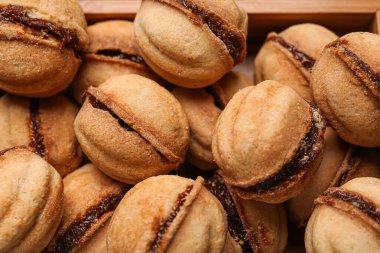 Ahşap kutuda kaynamış konsantre sütle ceviz şeklinde kurabiyeler, yakın plan.