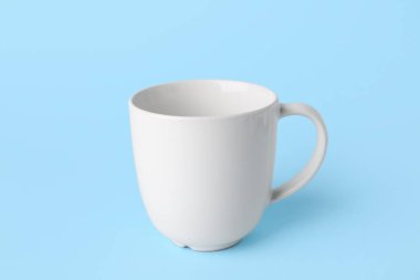 Mavi arkaplanda beyaz boş seramik bardak