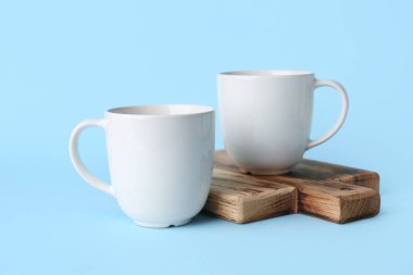 Mavi arkaplanda beyaz seramik boş kupalar