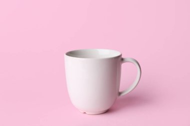 Pembe arka planda beyaz seramik boş bardak