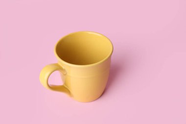 Pembe arka planda sarı seramik boş bardak