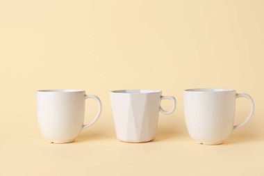 Bej arkaplanda beyaz seramik boş kupalar