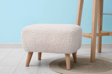 Beyaz puf, mavi duvarın yanında.