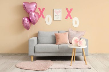 İçinde kanepe, hediye kutuları ve kalp şeklinde balonlar olan festival salonu. Sevgililer Günü kutlaması