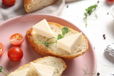 Ekmek tabağı, lezzetli işlenmiş peynir üçgenleri, domates ve mikro yeşil ışık masası, yakın plan.