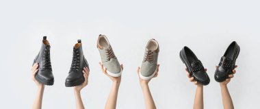 Beyaz arka planda şık ayakkabılı eller