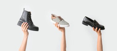 Beyaz arka planda şık ayakkabılı eller