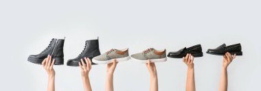 Beyaz arka planda şık ayakkabılı eller