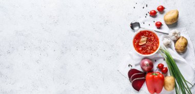 Bir kase lezzetli borş çorbası ve hafif arkaplanda malzemeler