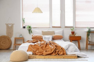 Yatak odasının içi büyük yatak ve komodinlerle dolu.