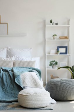 Büyük rahat bir yatak, raflar ve yatak odasının içi puf dolu.