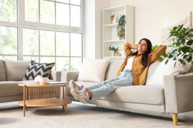 Güzel bir kadın sabahları evdeki kanepede dinleniyor.