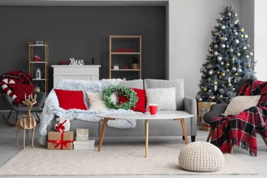 Oturma odasının içinde Noel ökseotu çelengi ve masa var.