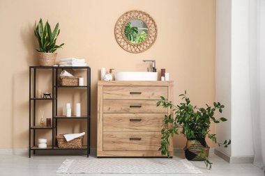 Lavabosu, raf ünitesi ve yanan mumları olan banyonun içi.