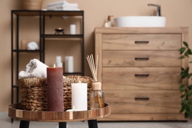 Banyodaki sepet ve havlularla mum yakmak, yakın plan.