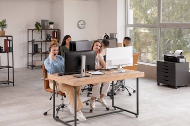 Ofisteki masalarda çalışan teknik destek ajanları