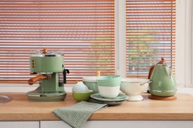 Kahve makineli güzel yemekler ve mutfak penceresinin yanındaki tezgahta çaydanlık.