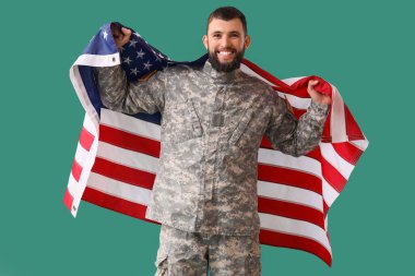 Yeşil arka planda Amerikan bayrağı taşıyan erkek asker