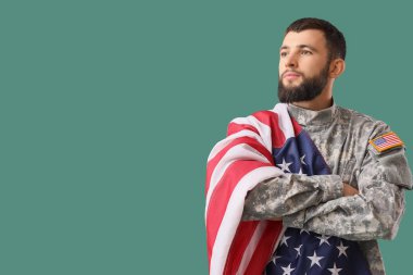 Yeşil arka planda Amerikan bayrağı taşıyan erkek asker